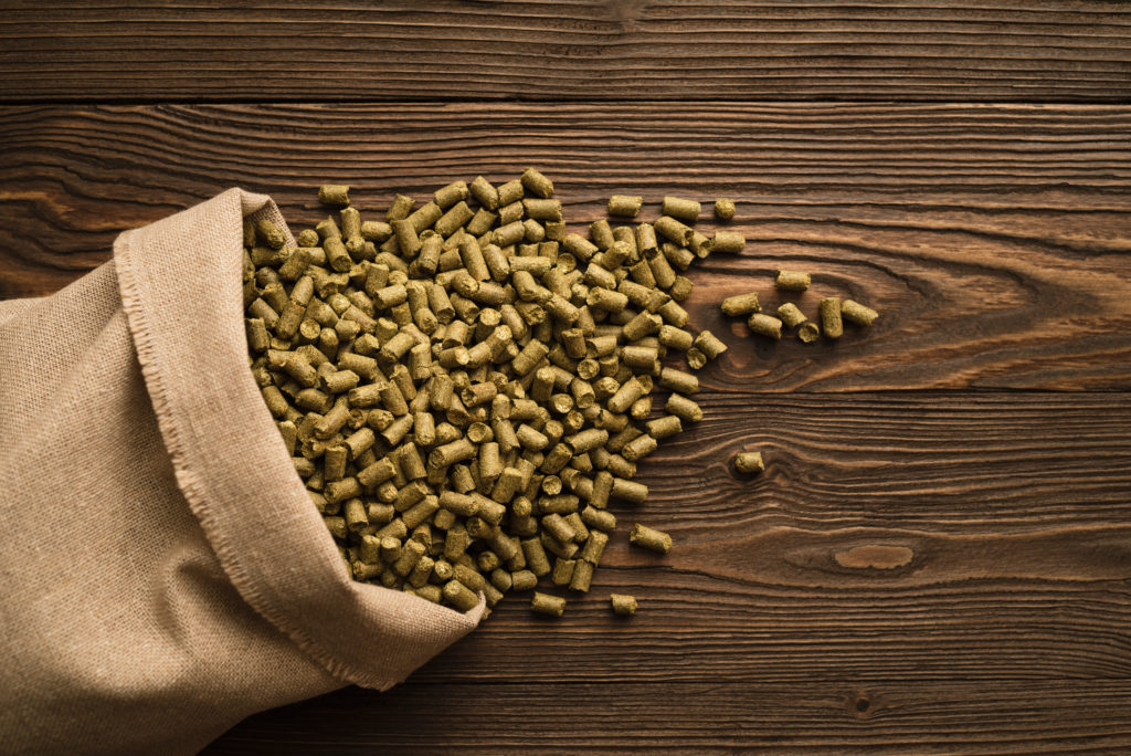 Granules of brewing hops on a wooden background